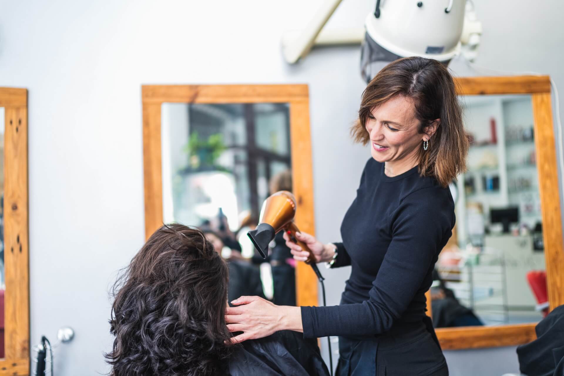 Hairdresser helping client at hair salon